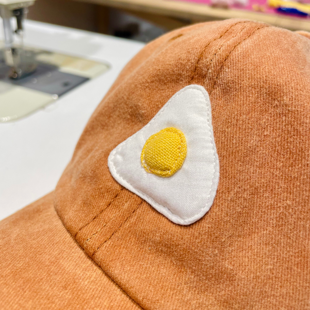 Casquette camel motif œuf au plat
