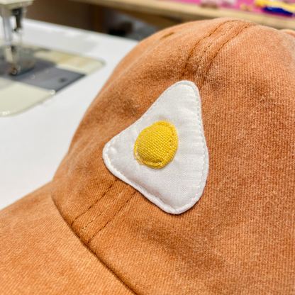 Casquette camel motif œuf au plat